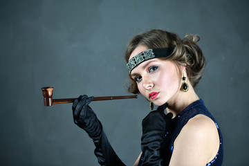 girl in evening blue dress with a pipe