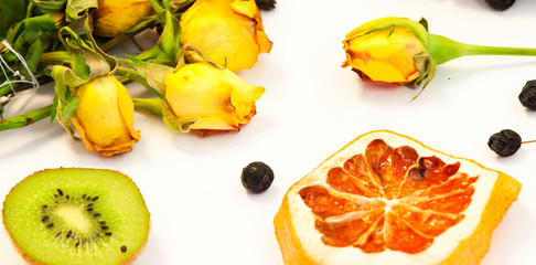 Red and yellow roses on a white background. Dry orange as decoration.