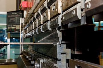 worker operating metal press machine at workshop.