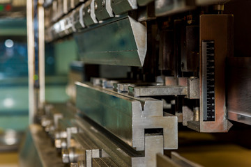 worker operating metal press machine at workshop.