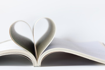 The love book, book's page rolls into the shape of heart on a white background.