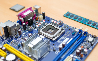 LGA socket on motherboard close-up. Blue motherboard. Processor and ram module beside.