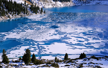 Bizarre forms of ice on a frozen mountain lake; figure of a running dog