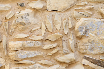 Background, old wall of stacked stone blocks with sharp edges of different shapes.
