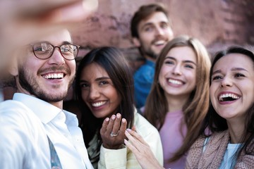 Obraz premium holidays, vacation and happiness concept - group of friends taking selfie with smartphone
