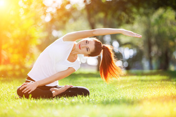 Yoga outdoor. Happy woman doing yoga exercises, meditate in the park. Yoga meditation in nature....