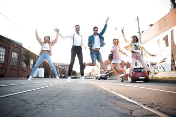 Group of young people having fun together outdoors in urban background.