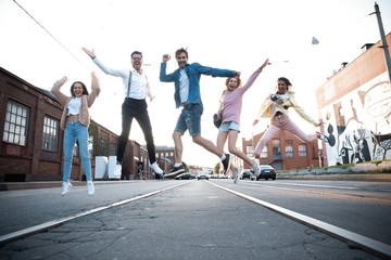 Group of young people having fun together outdoors in urban background.