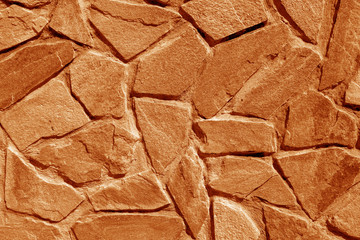 Wall made of old stones in orange tone.
