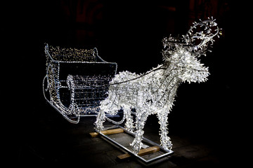 Christmas sleigh and deer in white led lights decoration. Black background