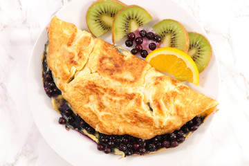 fried egg omelet with blueberries and fruits