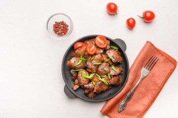 Homemade chicken liver fried with soy sauce, tomatoes, onions and spices on light background. Top view