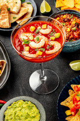 Mexican food, many dishes of the cuisine of Mexico on a black background. Shrimp cocktail, chili con carne, quesadillas, guacamole