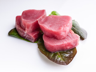 Tuna steaks on lettuce on a white background. Sea food