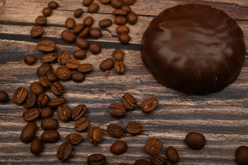 Marshmallow in chocolate and coffee beans on wooden background. Close up.