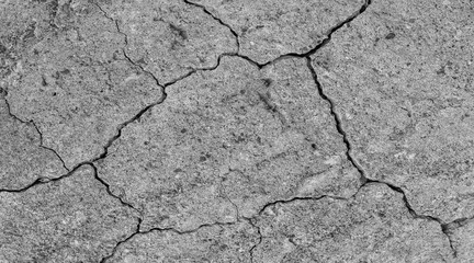 Cracked concrete texture closeup. Abstract cement background. Old concrete cement with cracks and natural destruction from time and weather conditions.