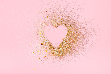 Golden glitter love heart on a pink background