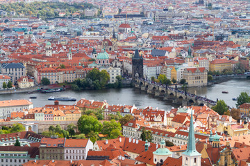 Naklejka na ściany i meble City views Prague autumn. Tiled roofs. The Charles Bridge. Vlatva river
