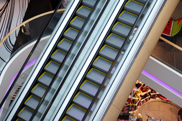 Modern bright shopping mall indoor architecture. Escalator in a shopping center. Interior of mall.