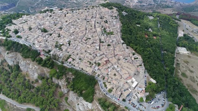 Aerial bird view footage of ancient town located on top of mountain at around 2500 feet above sea level showing the classic buildings and in background the surrounding flat land 4k high resolution