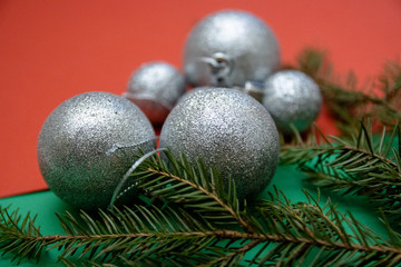 Fototapeta na wymiar Christmas photos with silver tree balls and conifer branches on a red-green background