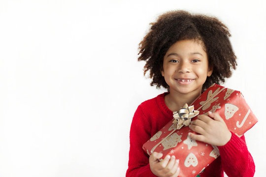 Happy adorable african american child girl  with christmas gift in hands isolated on white background