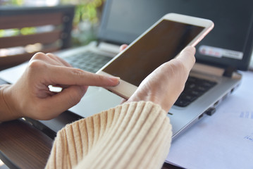 Close up hand hold cell phone mobile smart phone using technology and computer note book online internet