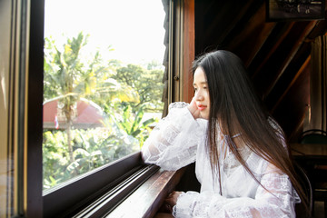 Portrait asian woman sitting next to window in restaurant