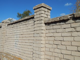Fototapeta na wymiar Brick fence. Old wall of gray brick.