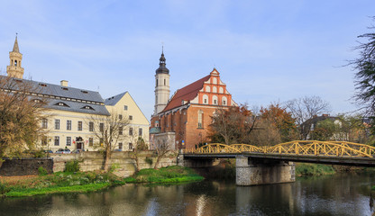Fototapeta premium Kanał Młynówki w Opolu w okolicy Mostu Zamkowego, zwanego też Mostem Żółtym. Za mostem kościół pod wezwaniem Trójcy Świętej