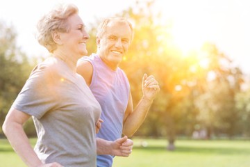Fototapeta premium Happy senior man looking at woman while jogging in park