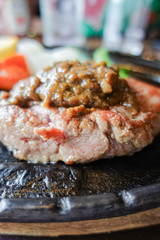 closeup grilled tenderloin steak on hot black metal plate