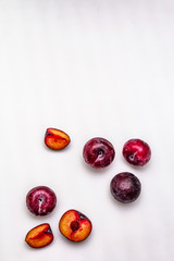 Ripe large purple plums. Fresh whole fruits, half sliced, seeds. Isolated on white background