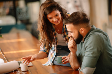 Colleagues in office. Businesswoman and businessman discussing work in office. Two friends in working together.  