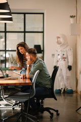 Colleagues in office. Businesswoman and businessman discussing work in office. Two friends in...