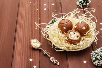 Homemade chocolate candies with star sprinkles. Festive sweet dessert, Christmas (New Year) spirit. Wooden boards background