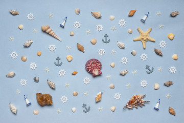 Various decorative nautical items, seashells, sea stars and miniature toys on blue pastel background. Sea travel, summer vacation at ocean concept. Flat lay, top view