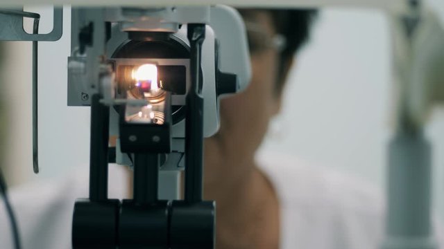 Female ophthalmologist working with medical device at clinic.