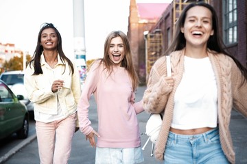 Outdoor shot of three young women having fun on city street