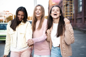 Outdoor shot of three young women having fun on city street