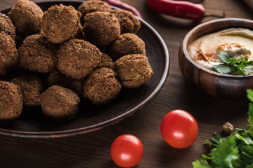 close up view of falafel balls near hummus on wooden table