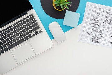 top view of laptop, computer mouse, plant, website design template on abstract geometric background