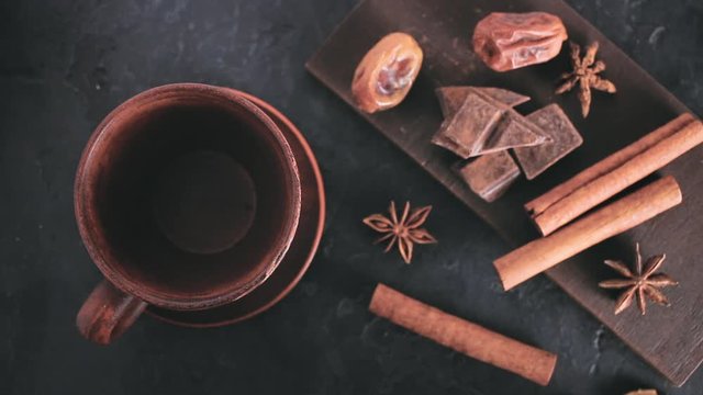 Man hand brings empty brown cup to the dark table before pouring coffee, top view