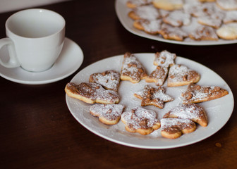 Homemade Christmas cookies on a white plate on a dark wooden table