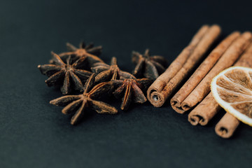 Traditional Christmas spices - Star anise with cinnamon and dry lime on a dark background.