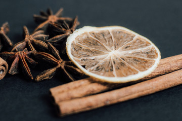Traditional Christmas spices - Star anise with cinnamon and dry lime on a dark background.