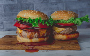 hamburger or sandwich. Delicious sandwich hamburger with meat, cheese and fresh vegetable. Hamburger or sandwich is the popular fast food for brunch or lunch. Juicy cheeseburger