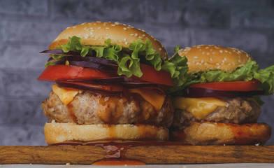 hamburger or sandwich. Delicious sandwich hamburger with meat, cheese and fresh vegetable. Hamburger or sandwich is the popular fast food for brunch or lunch. Juicy cheeseburger