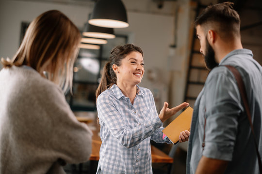 Colleagues having fun in office. Business people talking at workplace. 