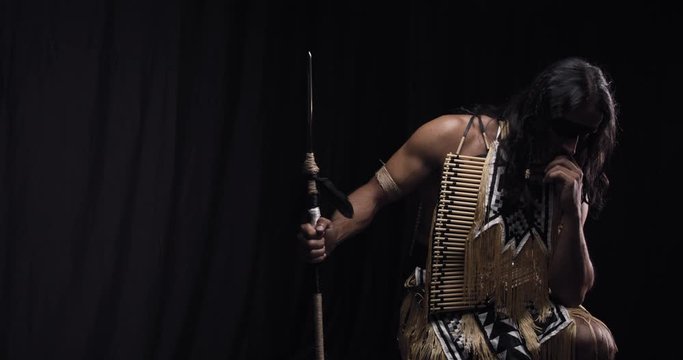 Sad thinking native american in national costume with a spear in hand, 4k